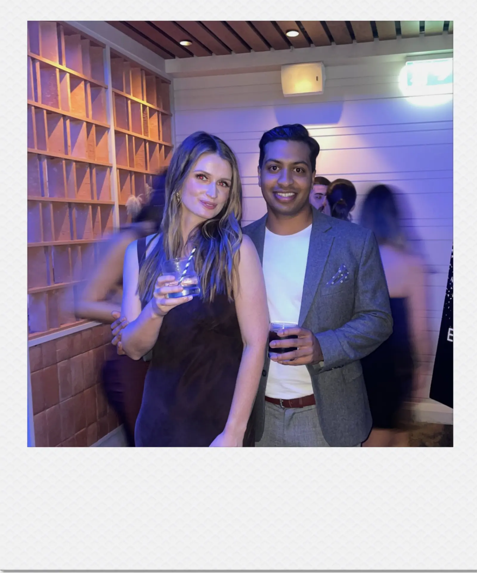 Hannah and Nihal at an evening party with drinks